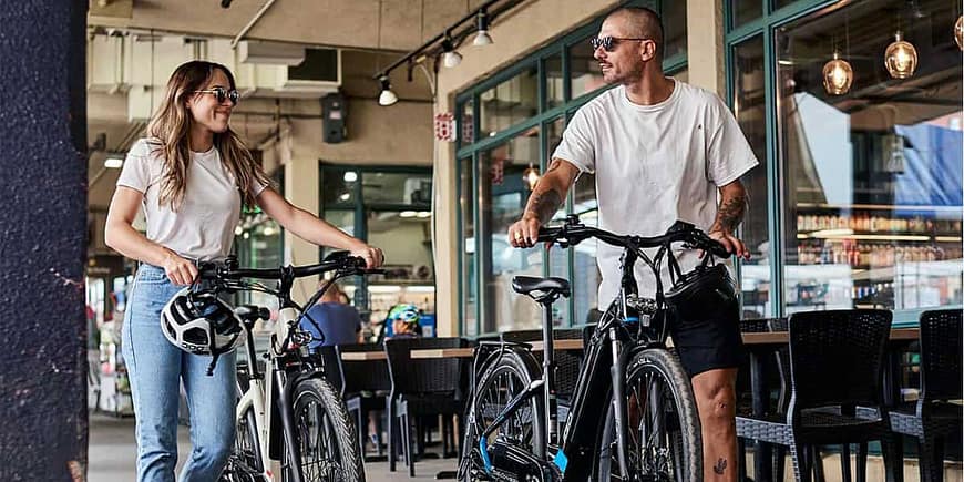 Couple with e-bikes in shopping area